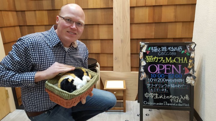 Ryan Buckles poses for a photo at the entry to one of the many interesting aspects of Japanese culture - pay a few dollars, pet a cat for 10 minutes!